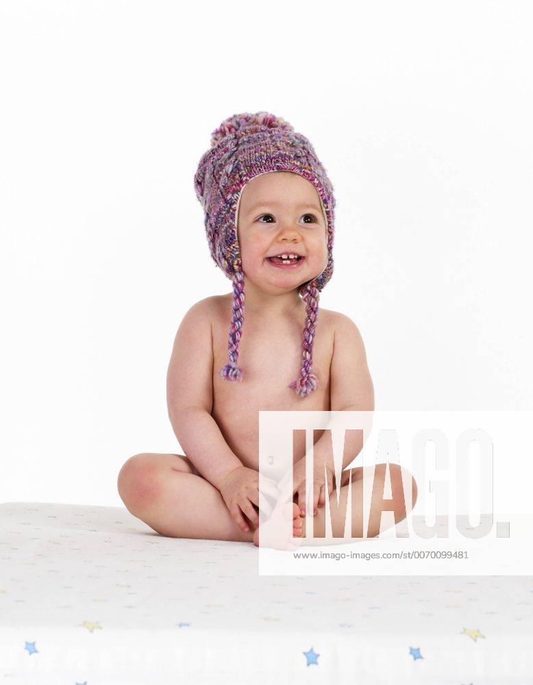 Portrait Of Happy Naked Baby Girl Wearing Woolly Hat Model Released