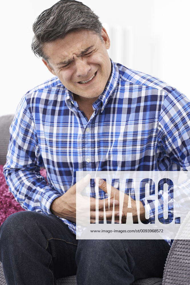 Mature Man Suffering From Stomach Pain At Home Model Released