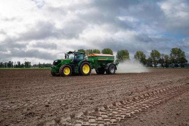 Arable Farming Tractor Spreading Lime On A Field With A Lime Spreader