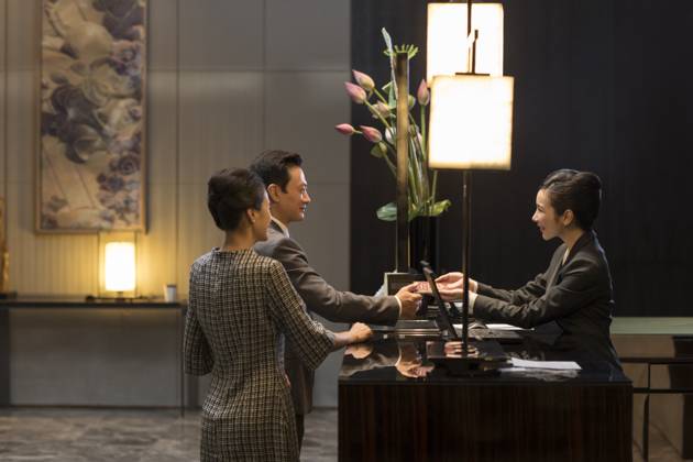 Chinese Couple Checking Into Hotel Beijing China