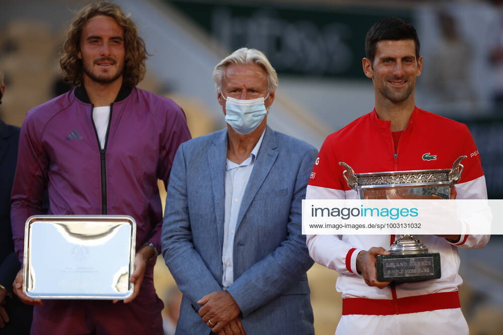 Final Men - French Open Novak Djokovic of Serbia embraces former tennis player Bjorn Borg as receives the trophy after winning his Men s Singles Final match against Stefanos Tsitsipas of Greece who looks dejected in the background during Day Fifteen of the 2021 French Open at Roland Garros on June 13, 2021 in Paris, France. Paris France taamallah-notitle210613_npd7Y