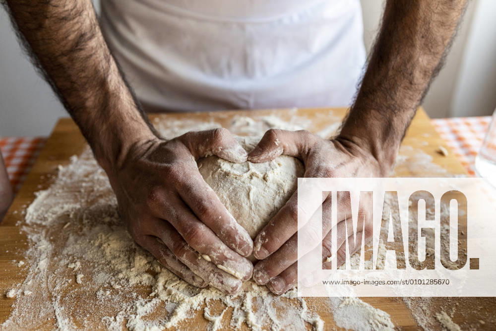 Mans hands shaping heart on dough ball model released Symbolfoto WPEF02885