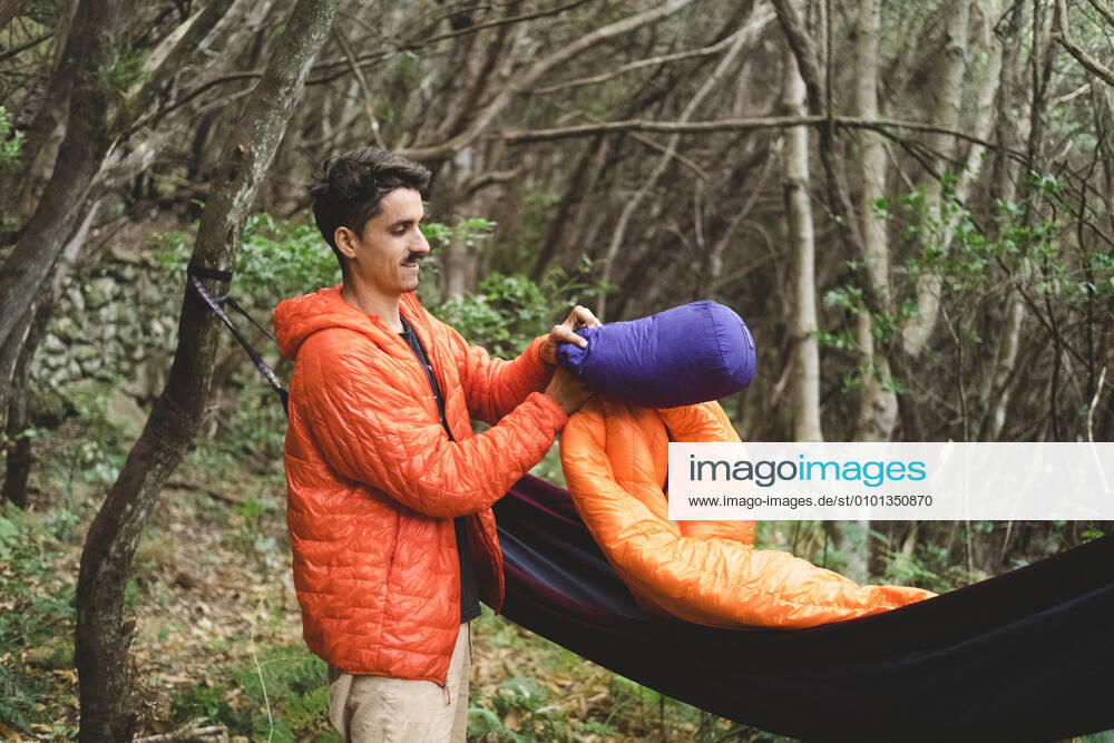 A man packs a sleeping bag and hammock at campsite in the forest Santa Cruz de Tenerife, CN, Spain CR_SEVI200402-201019-01,model released, Symbolfoto