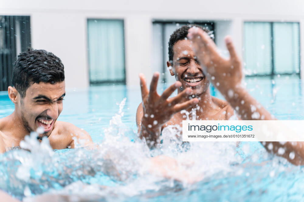 IMAGO Creative, Jahreszeit Sommer, Sommerferien Man smiling as he plays in a circle with a group of friends in a pool Kuching, Sarawak, Malaysia CR_TECM200409A-341665-01,model released, Symbolfoto
