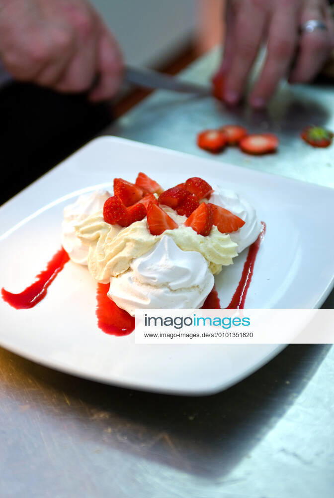 Chef preparing pavlova with fresh strawberries and cream Egham, England, United Kingdom CR_THHE200407A-344891-01,model released, Symbolfoto ,property released