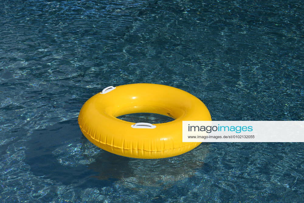 Symbolic image of an open-air swimming pool a yellow swimming tire floating on the surface of a swimming pool, Löffingen, Baden Württemberg, Germany