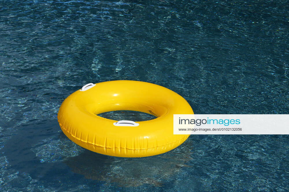 Symbolic image of an open-air swimming pool a yellow swimming tire floating on the surface of a swimming pool, Löffingen, Baden Württemberg, Germany