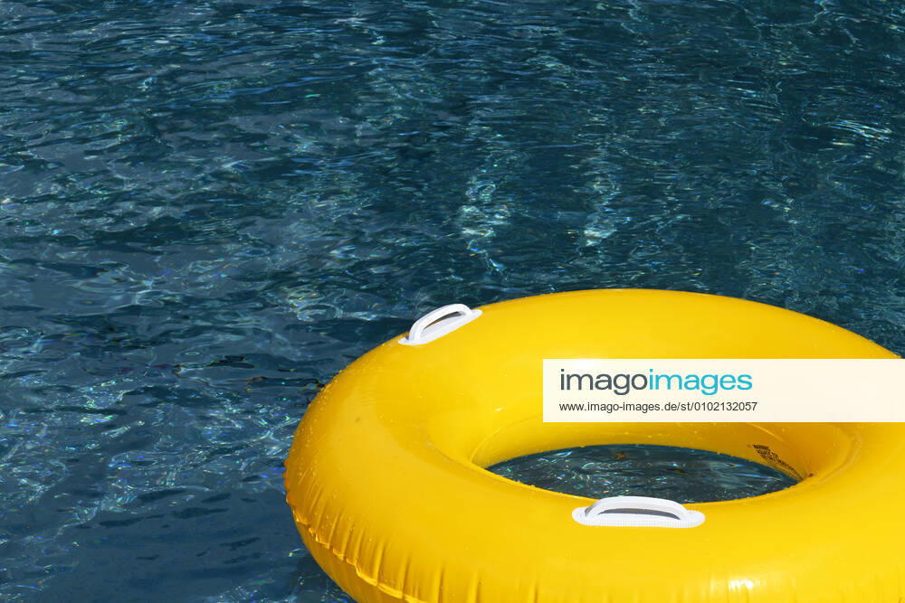 Symbolic image of an open-air swimming pool a yellow swimming tire floating on the surface of a swimming pool, Löffingen, Baden Württemberg, Germany