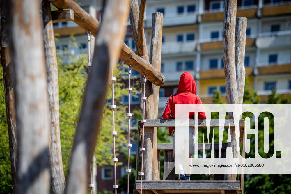 Leipzig Saxony , Gruenau district A child is standing on a playground in front of a prefabricated building in Leipzig Gruenau