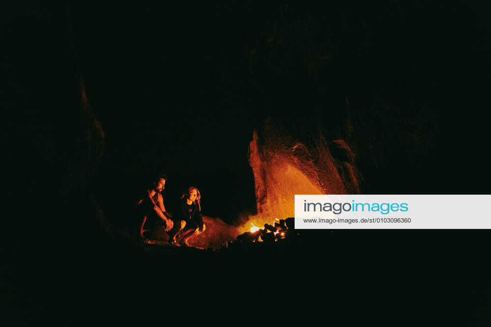 IMAGO Creative: Klimawandel - Nachhaltiges Reisen Young couple in front of camp fire at night in northern California. Lone Pine, CA, United States CR_JUSLKY200806-466831-01 ,model released, Symbolfoto