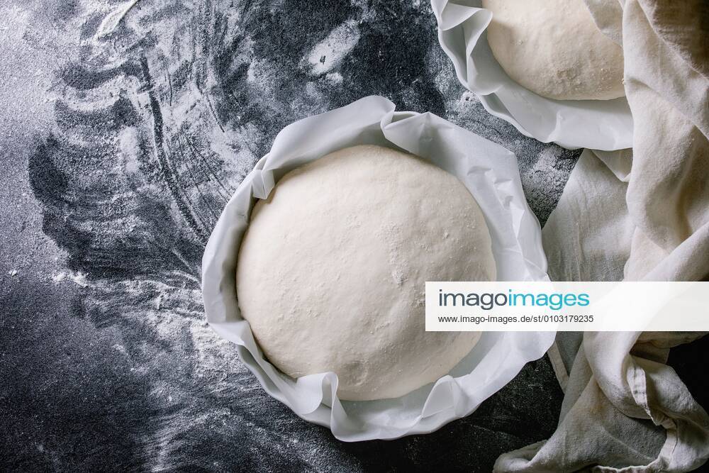 Process of making homemade bread. Fresh dough redy for baking on baked paper over black table with flour. Home bread baking. Photo series. Flat lay, space ÂNatashaBreen REDA&CO 1028_29_NBR8111