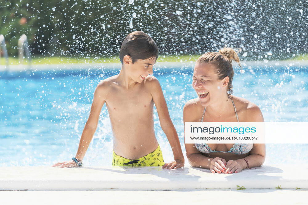 Shirtless boy looking at mother laughing in swimming pool model released Symbolfoto DLTSF00905