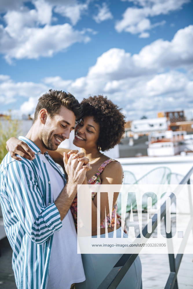 Happy multi-ethnic couple dancing on penthouse patio model released Symbolfoto property released EHF00608