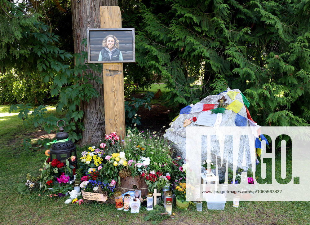 Here in the picture the memorial, temporary memorial for the former biathlete, Laura Dahlmeier from Garmisch Partenkirchen, who died in a mountaineering accident on Laila Peak, Karakorum Mountains in Pakistan, in the small spa park with a picture photo, numerous flowers and candles and a stone that looks like a mountain and is provided with Tibetan prayer flags and a saying sign, say goodbye.