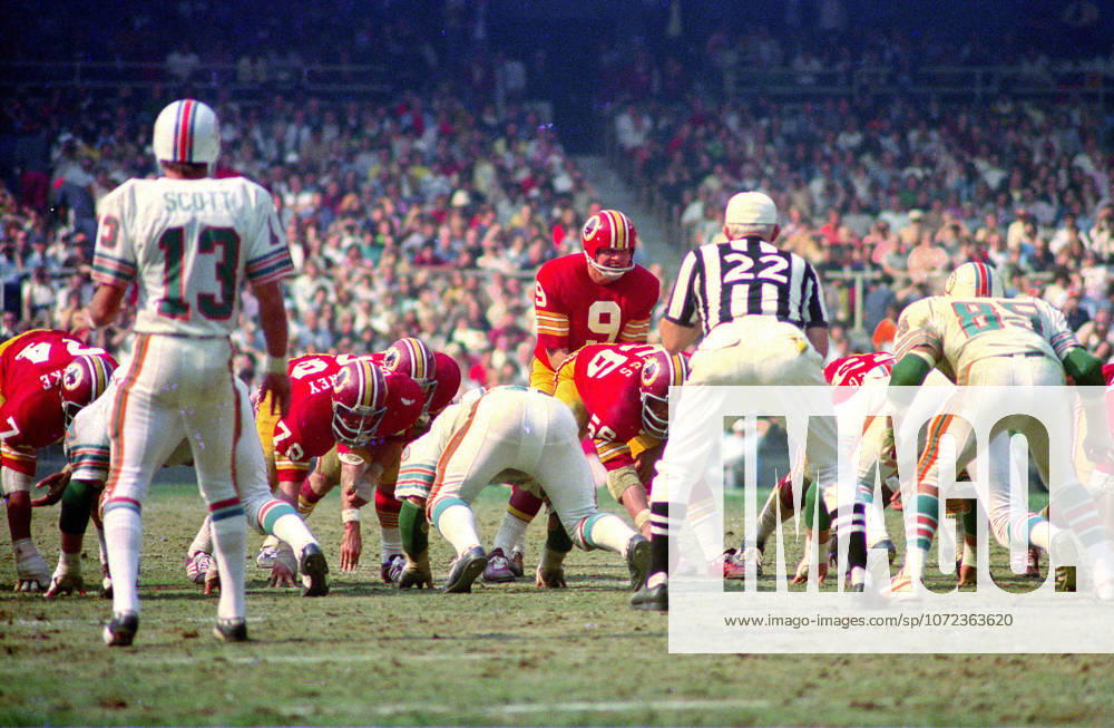 Washington Redskins quarterback Sonny Jurgensen 9 calls signals as he prepares to take the snap from center Len Hauss 56 during the game against the Miami Dolphins at RFK Stadium in Washington, DC on October 13, 1974. Also pictured are Redskins right tackle George Starke 74, Dolphins free safety Jake Scott 13, Redskins right guard Walt Sweeney 78, and Dolphins middle linebacker Nick Buoniconti 85. The Redskins won the game 20 - 17. Washington USA - ZUMAs152 19741013_faa_s152_002