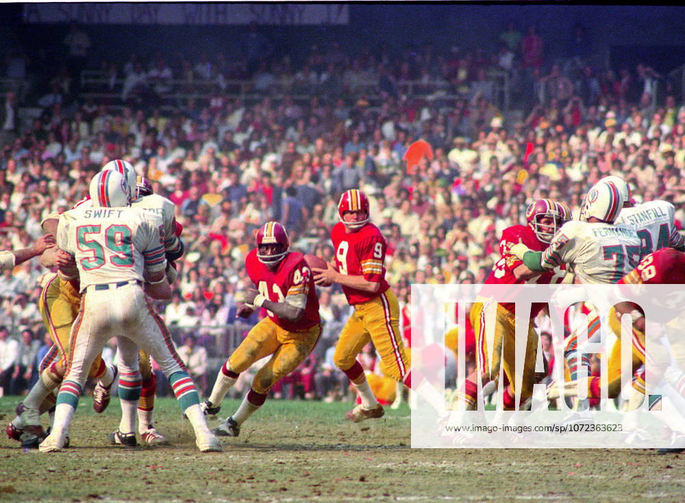 Washington Redskins quarterback Sonny Jurgensen 9 looks for a receiver during the game against the Miami Dolphins at RFK Stadium in Washington, DC on October 13, 1974. Also pictured are Dolphins left linebacker Doug Swift 59, Redskins running back Larry Brown 43, Redskins right guard Walt Sweeney 78, Dolphins left defensive tackle Manny Fernandez 75, and Dolphins right defensive end Bill Stanfill 84. The Redskins won the game 20 - 17 Washington USA - ZUMAs152 19741013_faa_s152_005