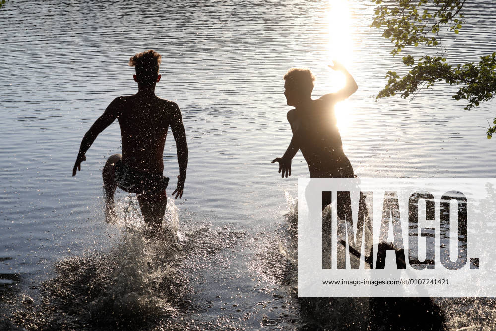 Dranse, Brandenburg, GER Silhouette Teenagers and dog run into a lake MR yes, 1