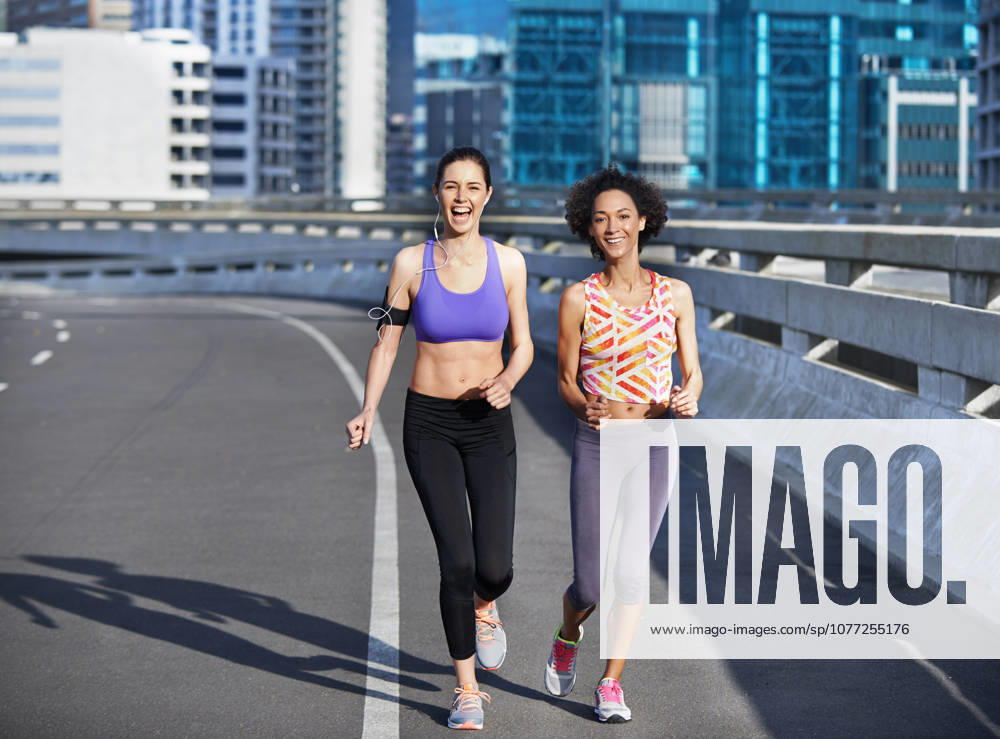 Running isnt just about fitness. two friends jogging together through the city streets (License=RF) 20318904 ,model released, Symbolfoto