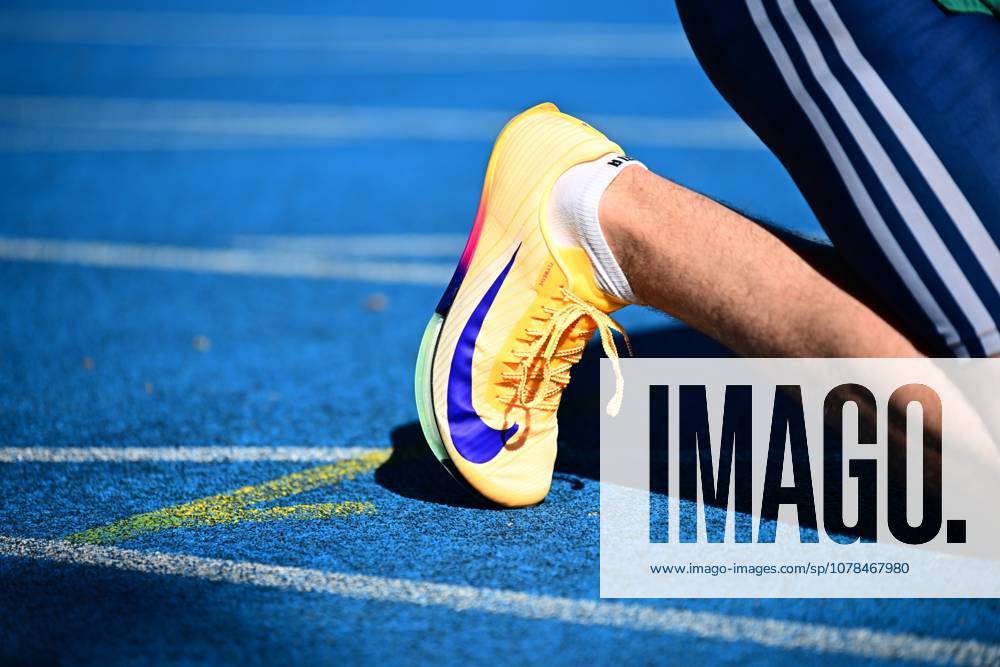 A yellow Nike sprint shoe with a blue Swoosh logo lies on the blue tartan track of the Michael Hoffmann Stadium in Mannheim The athletes bib number is not legible, personal identification is not possible Close-up of a Nike sprint shoe on the blue tartan track