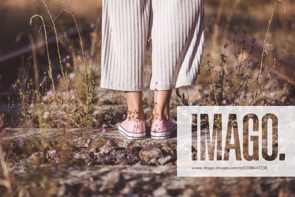 IMAGO Creative: Gesellschaft, Mobilit?t auf dem Land Long haired woman standing on railways overgrown with dry grass
