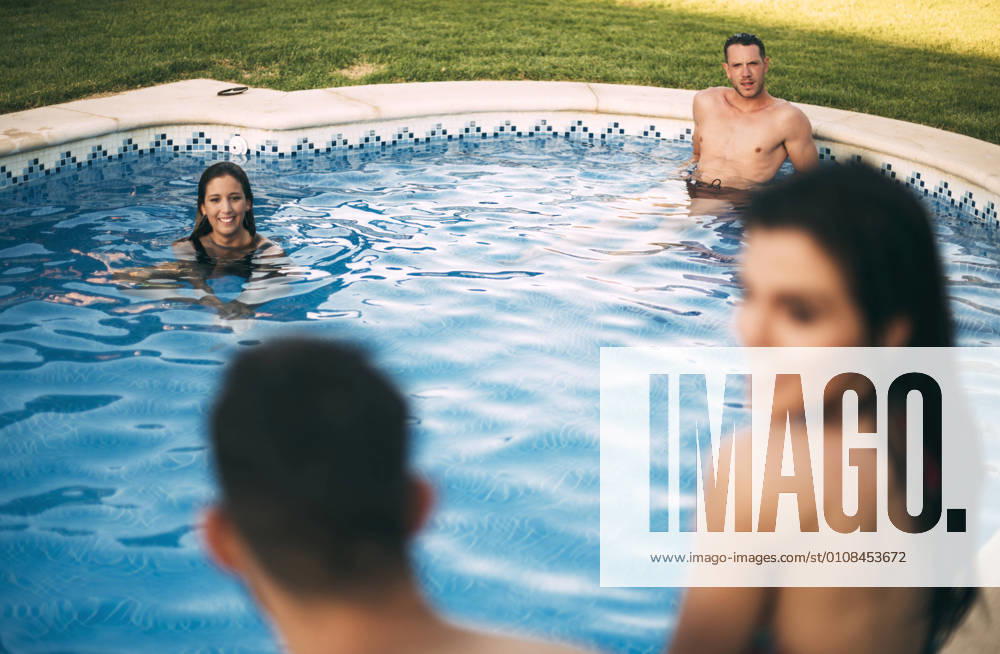 Friends sitting on edge of pool, Model released, Property released