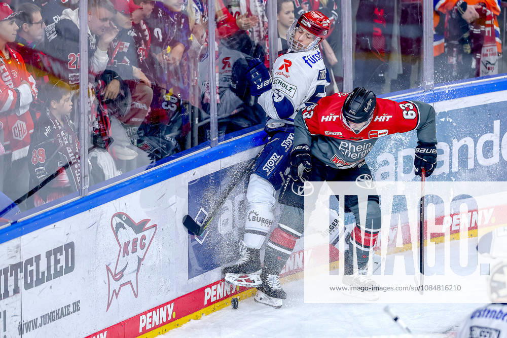 Ice Hockey, DEL, Kölner Haie vs. Schwenninger Wild Wings, Matchday 49, 2026–27 Season, Lanxess Arena, Cologne: Alex Trivellato (SWW 53) battles Patrick Russell (Cologne Sharks 63) for the puck along the boards in North Rhine-Westphalia, Germany
