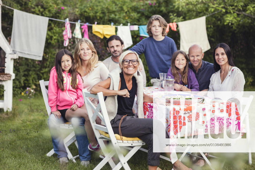 IMAGO Creative, Jahreszeit Sommer, Sommerferien Portrait of happy family and friends in back yard during garden party , model released, property released