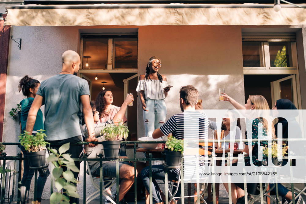 Multi-ethnic friends enjoying at balcony during party , model released, property released