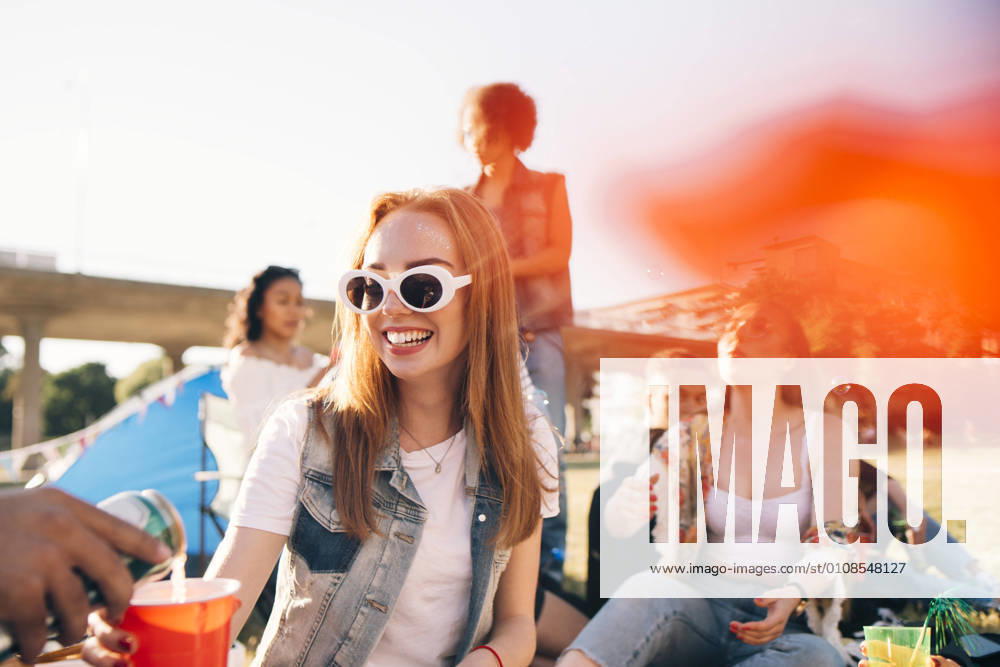 Cropped image of man pouring alcohol to smiling woman at festival , model released