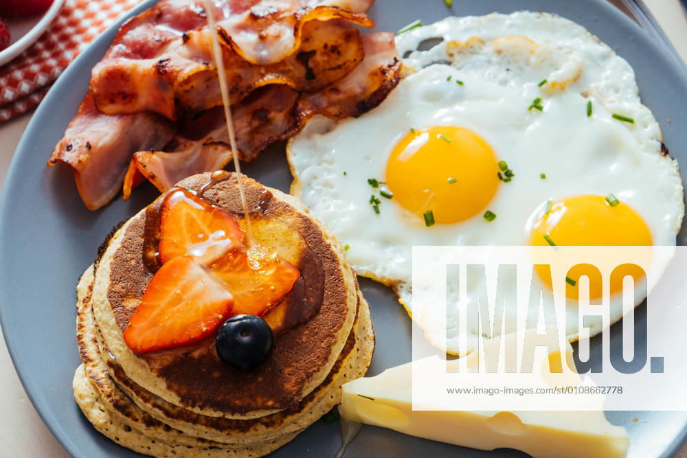 Delicious fried eggs with bacon and cheese for breakfast, Model released