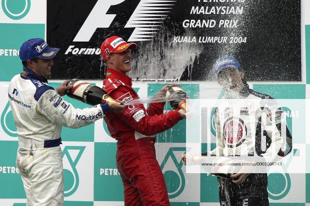 Siegerehrung GP Malaysia 2004, v.li.: Juan-Pablo Montoya (Kolumbien BMW-Williams), Michael Schumacher (Deutschland Ferrari) und Jenson Button (England BAR-Honda) feiern mit einer Sektdusche Motorsport Grand Prix Herren Großer Preis von Malaysia 2004, Formel 1 Weltmeisterschaft, F1, F, GP, WM Gruppe Sepang Kuala Lumpur Freude, Begeisterung,