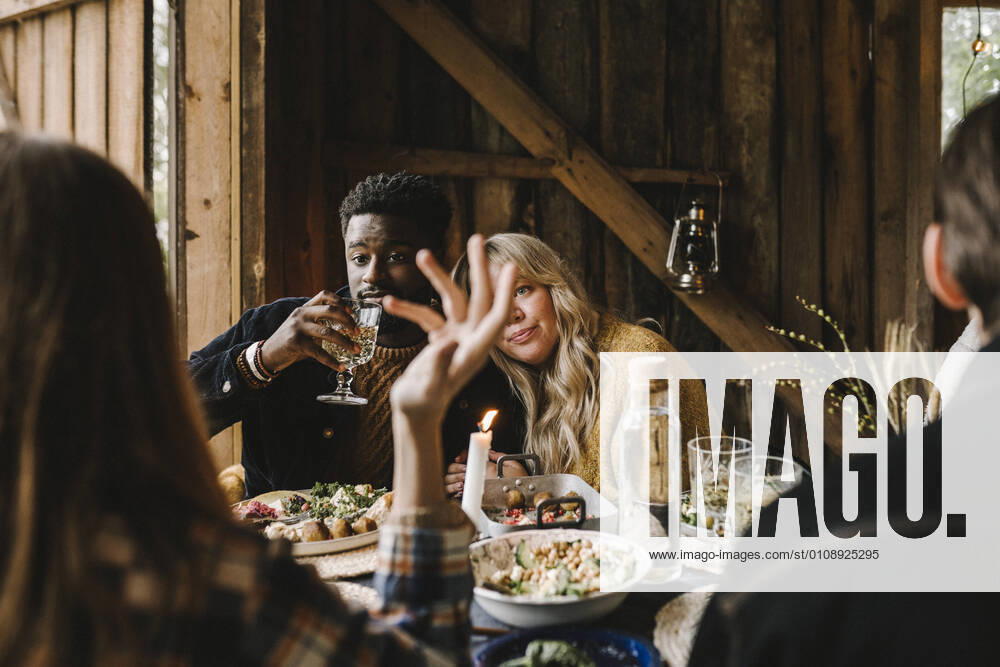 IMAGO Creative: Landleben - Essen Rear view of woman gesturing while female resting head on friend s shoulder during social gathering Sweden, Stockholm, model released, property released