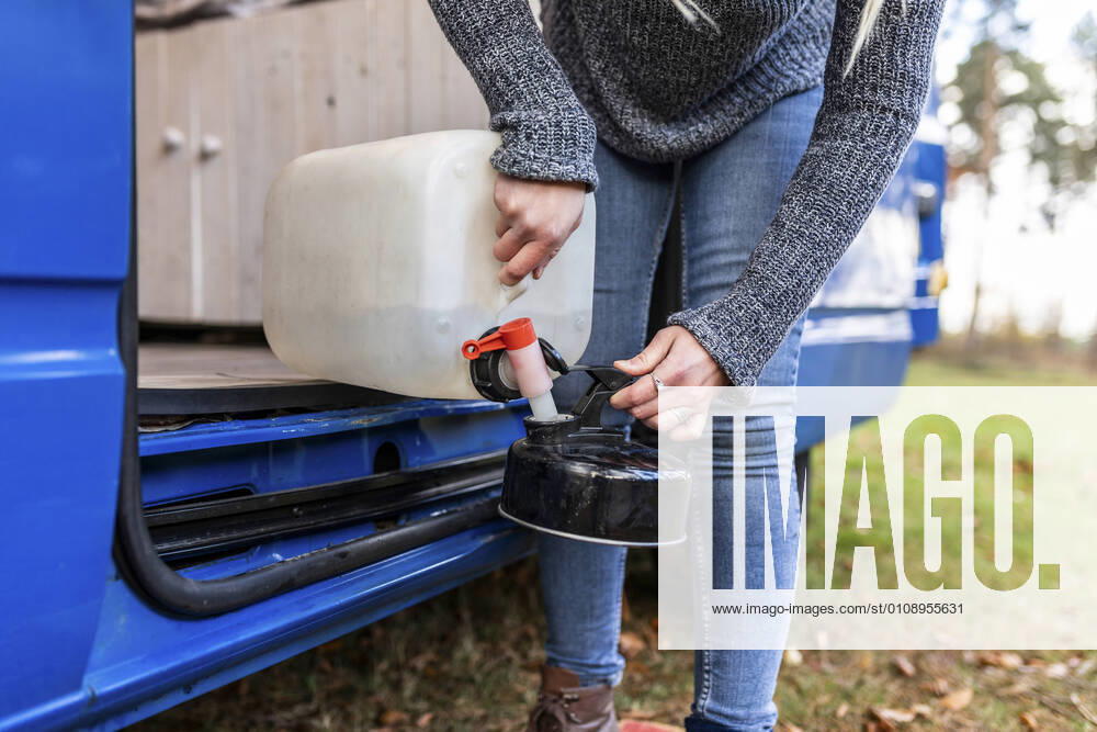 IMAGO Creative: Klimawandel - Nachhaltiges Reisen Mid adult woman pouring water in camping teapot model released Symbolfoto WPEF03783
