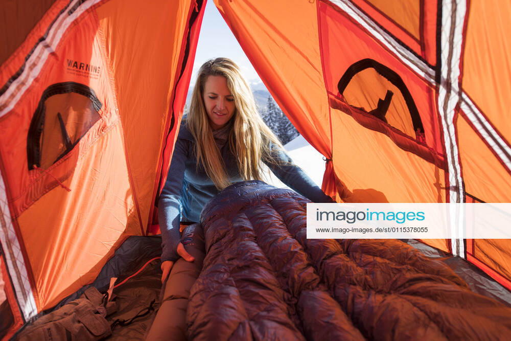 Young female setting up sleeping bag in tent while winter camping Aspen, CO, United States CR_BRHU210312-245189-01 ,model released, Symbolfoto