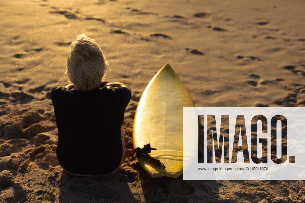 IMAGO Creative: Sommer Sport - Strand Old woman with a surfboard at the beach Rear view of a senior Caucasian woman at the beach at sunset, sitting on the sand with a surfboard beside her, looking out to sea, model released, , property released, Cape Town, South Africa, 21.11.2019, 1313682.jpg, people,real people,enjoy,enjoying,pleasure,lifestyle,free time,holidays,vacation,weekend,activity,relaxing,health,healthy,outdoorsy,fit,leisure,beach,coast,coastal,sand,sunny,summer,retirement,sport,sports,surfing,surfboard,sportswear,wetsuit,happy,confident,freedom,water sport,sports equipment,hobbies,sunset,sundown,sitting,tranquility,thinking,active seniors Senior,Elderly,Woman,Female,Caucasian Outdoors,Rear view,Focus on Foreground,Looking Away,Single object,Dusk-Twilight,Full lengt