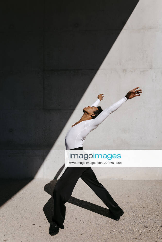 Male dancer practicing against wall on sunny day model released Symbolfoto TCEF01578