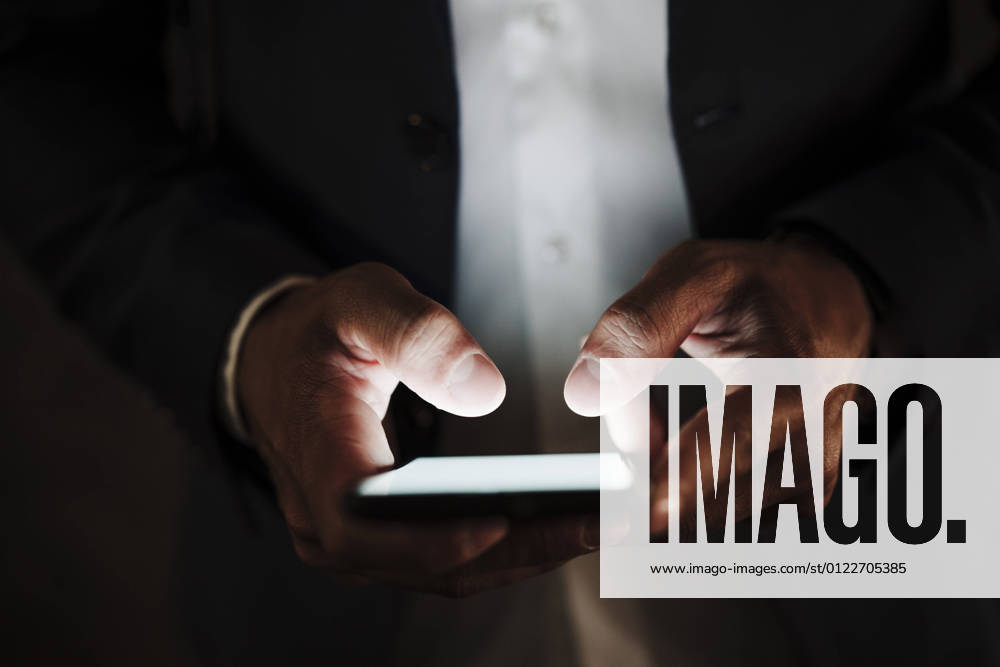 Male entrepreneur using smart phone in dark model released Symbolfoto EBBF04014