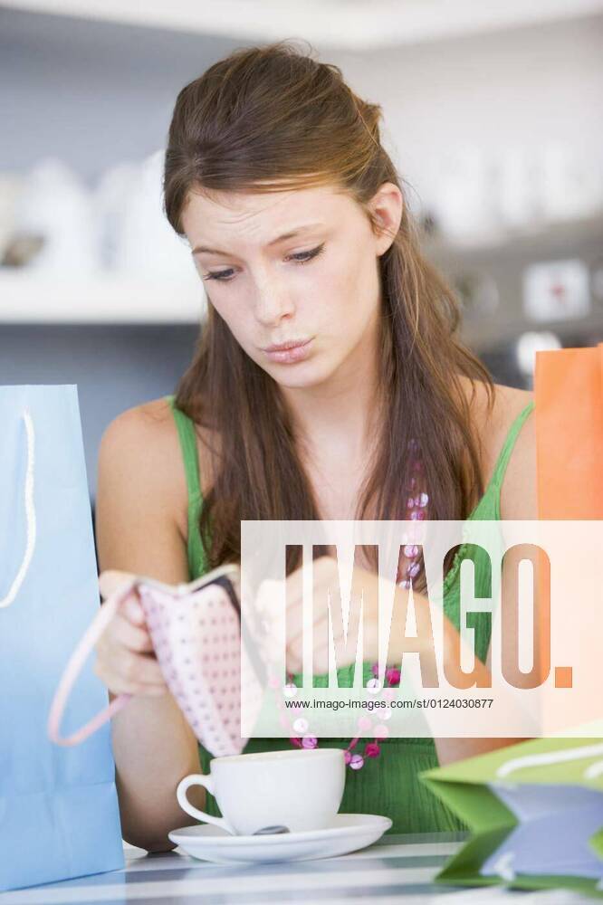 IMAGO Creative: Gesellschaft, Armut Young woman sitting at a table checking change purse model released, Symbolfotoproperty released, , 10.03.2011 17:10:34,