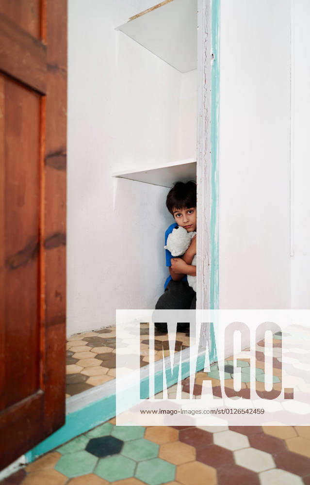 IMAGO Creative: Jahreszeit Winter, Fantasievoll drinnen spielen Unhappy scared little boy with toy hiding in wardrobe while suffering from domestic violence, Model released AdalbertoRodriguez_ChildAbuse_7.jpg