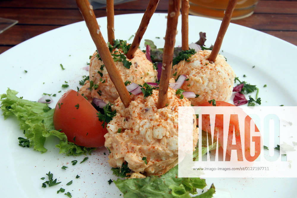 Bavarian speciality Obazda with salt sticks stands on a table of a Bavarian beer garden in Wiesbaden, Hesse, Germany