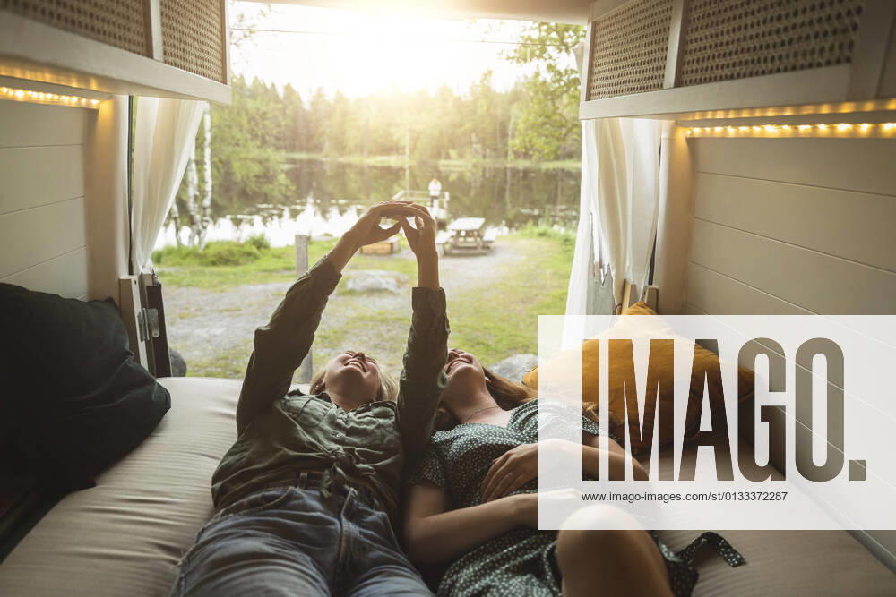 IMAGO Creative: Ende des Sommers Female Friends taking selfie through smart phone in camping van Sweden, Gothenburg, model released, property released