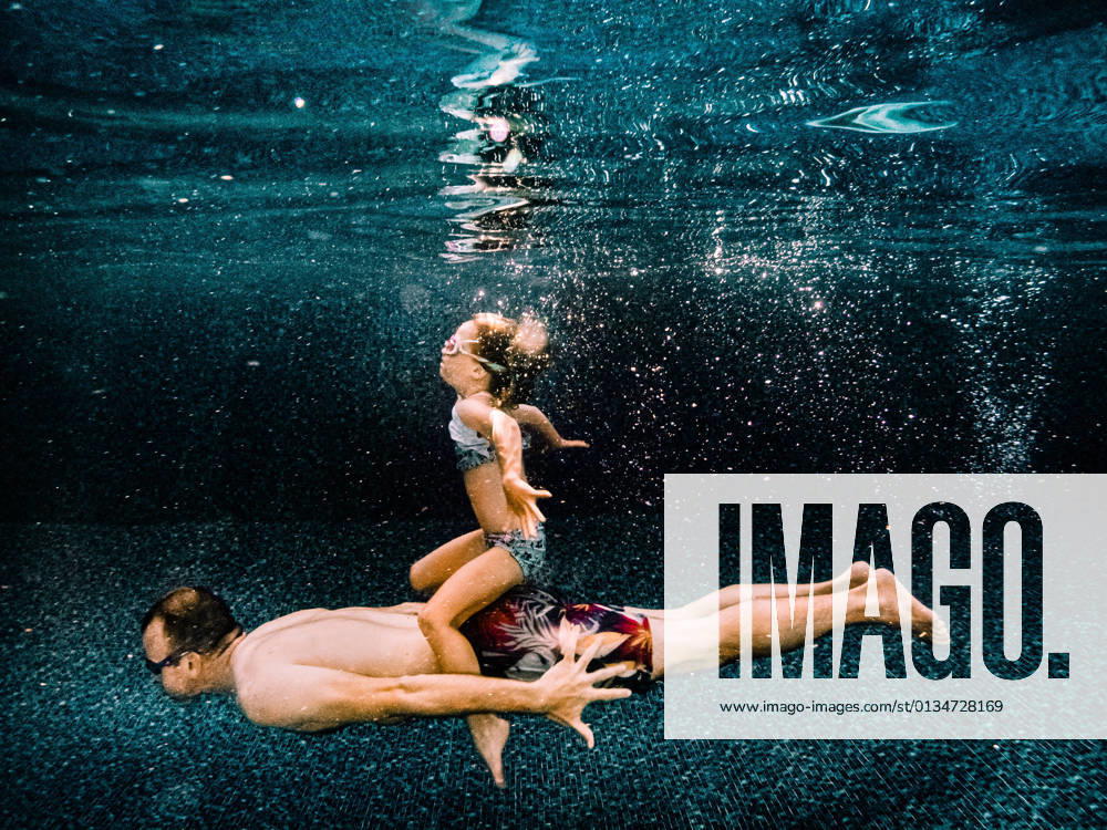 IMAGO Creative: Frühlingsferien und reisen daughter and father swimming together in a pool during summer Quebec City, Quebec, Canada CR_TYTZ210729-806050-01 ,model released, Symbolfoto