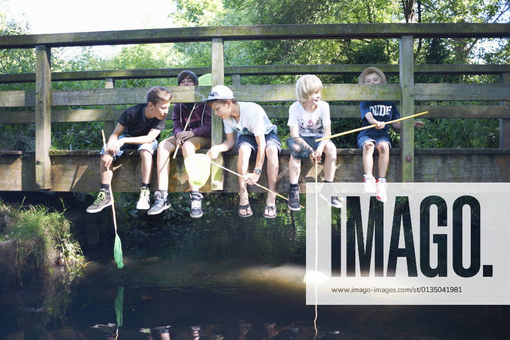 IMAGO Creative, Jahreszeit Sommer, Sommerferien Boys sitting on bridge, fishing, 31.07.2014,