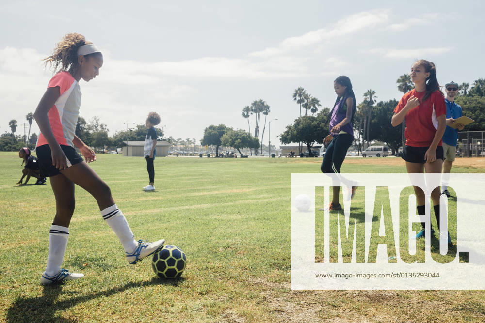 IMAGO Creative, Jahreszeit Sommer, Sommerferien IMAGO Creative: Internationaler Frauenmonat, Mädchen im Sport Schoolgirls practicing face to face with soccer ball on school sports field, 12.12.2017,