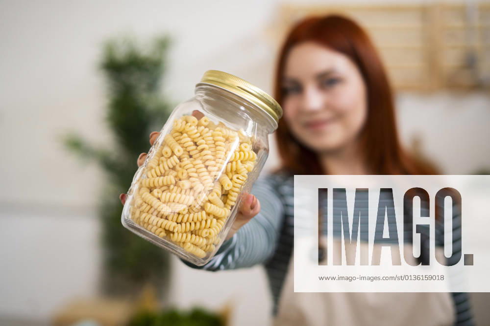 Woman holding pasta jar in kitchen model released Symbolfoto property released GIOF13223