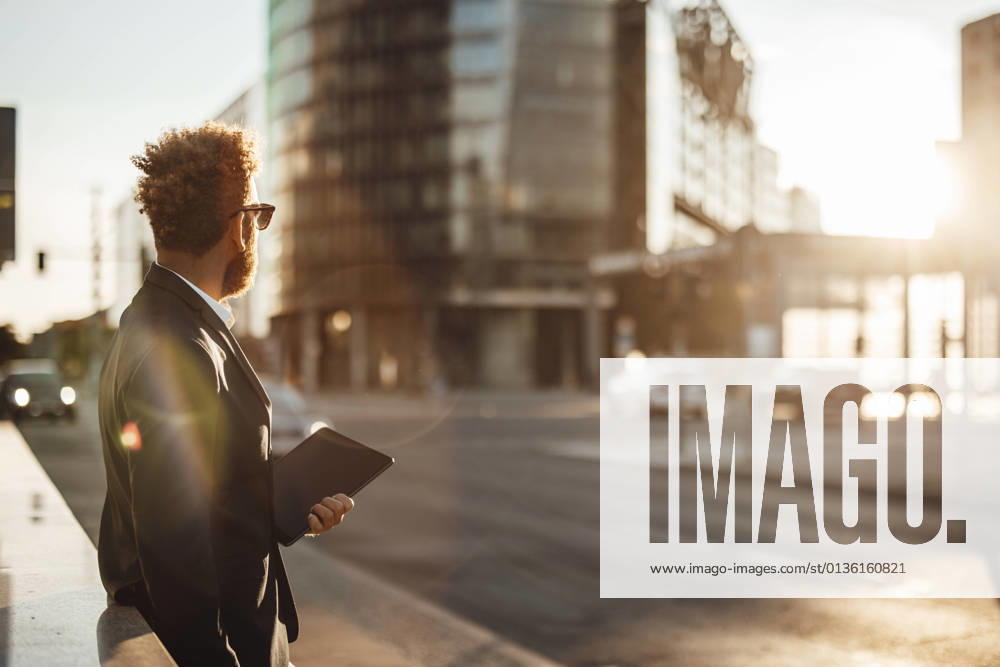 IMAGO Creative, Jahreszeit Sommer, Sommer in der Stadt Businessman holding digital tablet on footpath during summer model released Symbolfoto GUSF06347