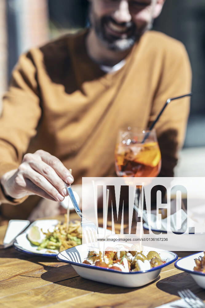IMAGO Creative, Food, Tapas Smiling man eating tapas at restaurant model released Symbolfoto property released JSRF01607