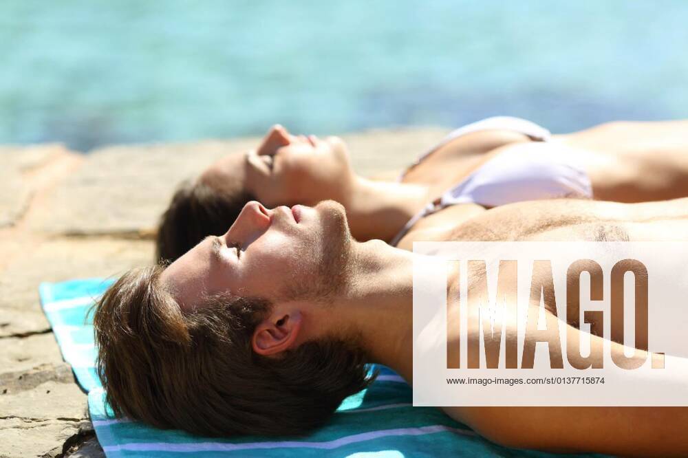 IMAGO Creative, Jahreszeit Sommer, Sonnenschutz Couple sunbathing on summer vacation on the beach model released, Symbolfoto, 13.10.2020,