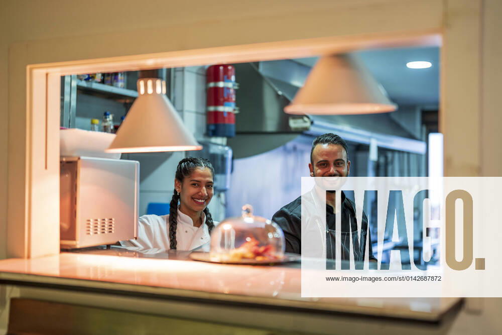 IMAGO Creative: Internationaler Frauentag, Gender Pay Gap, Frauen verdienen 18 Prozent weniger IMAGO Creative: Landleben - Essen Smiling chef and trainee in commercial kitchen at restaurant model released property released, DLTSF02398