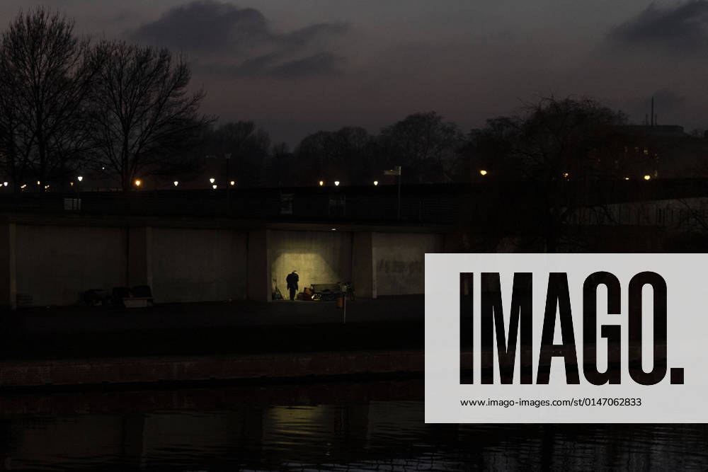 A homeless man stands out as a silhouette on the bank of the river Spree in Berlin, 11 01 2022 Berlin Germany
